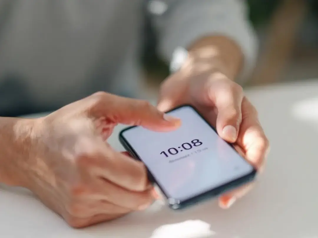 The image depicts a person's hands holding a smartphone stopwatch, timing the seizure activity of a dog experiencing a...
