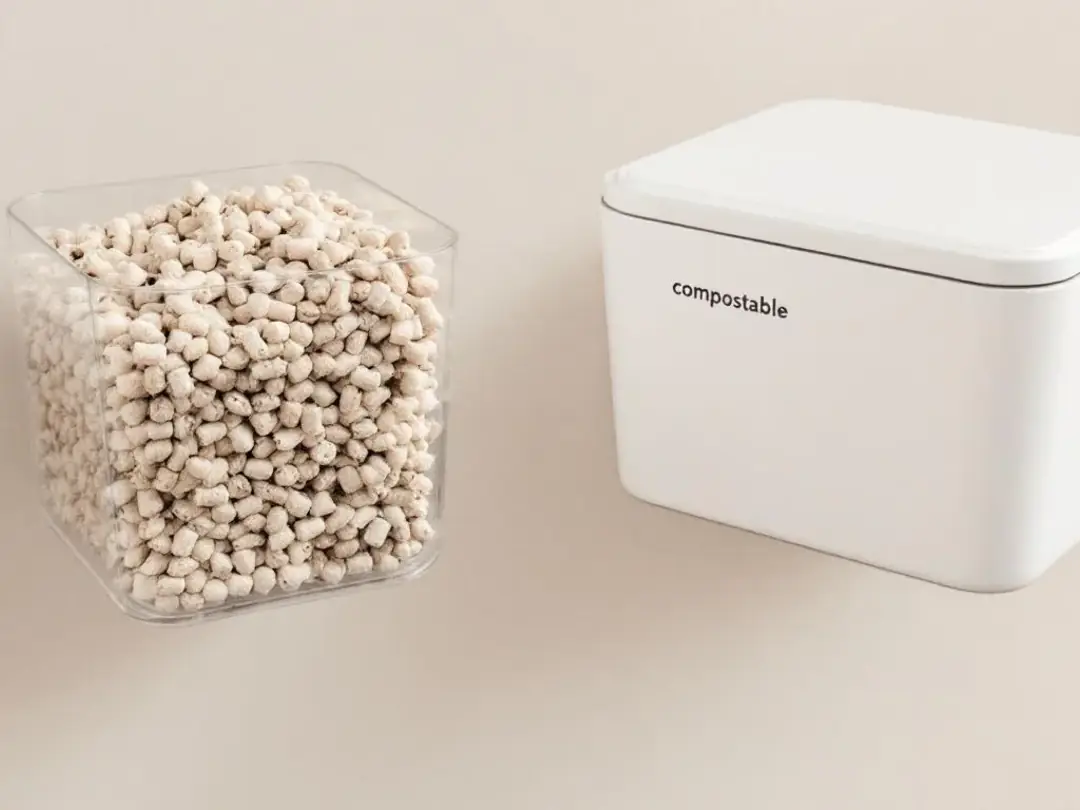 The image depicts an eco-friendly setup for handling soiled dog litter, featuring biodegradable dog litter pellets in a...