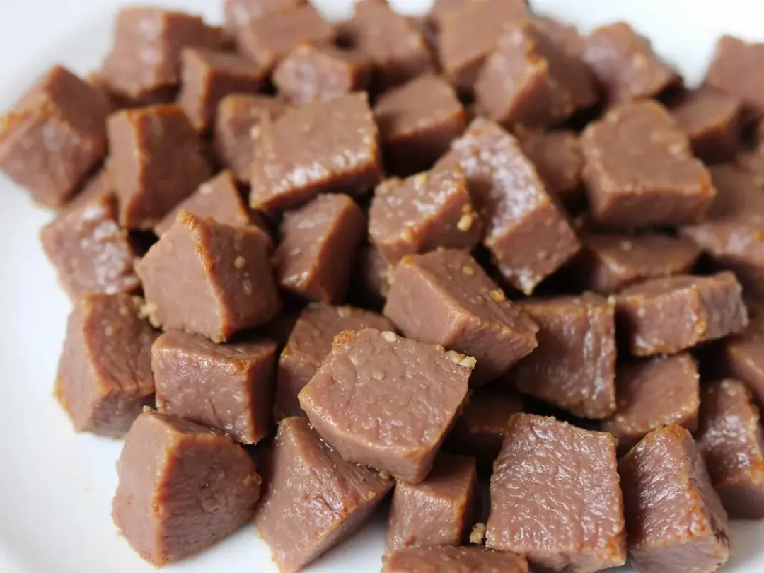 A plate holds small, bite-sized pieces of cooked beef liver, ideal for training treats for dogs. This nutrient-dense...