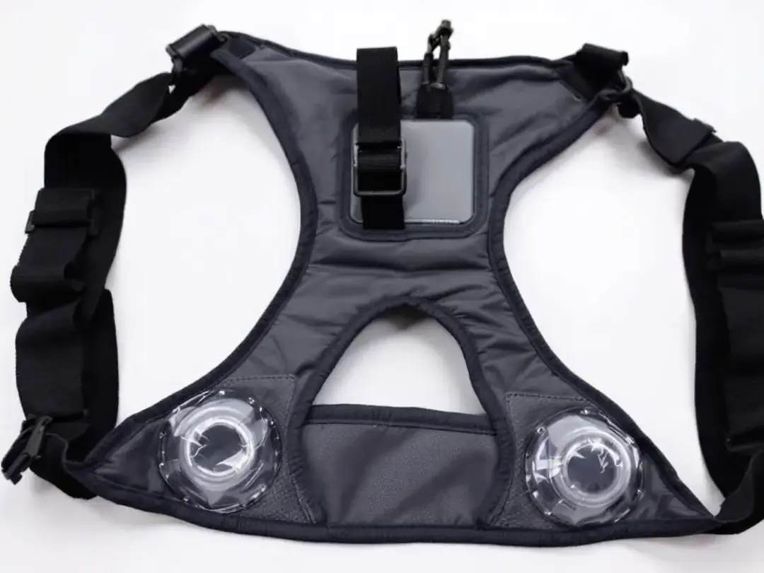 The image shows a step-in dog harness laid flat, featuring clear leg holes for easy placement of a puppy. This harness...